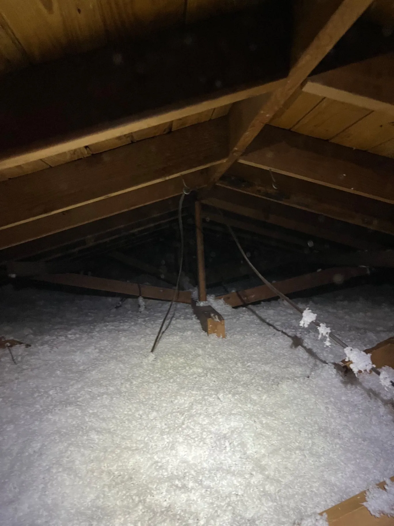 Fresh blown-in insulation evenly covering an attic floor around HVAC ductwork