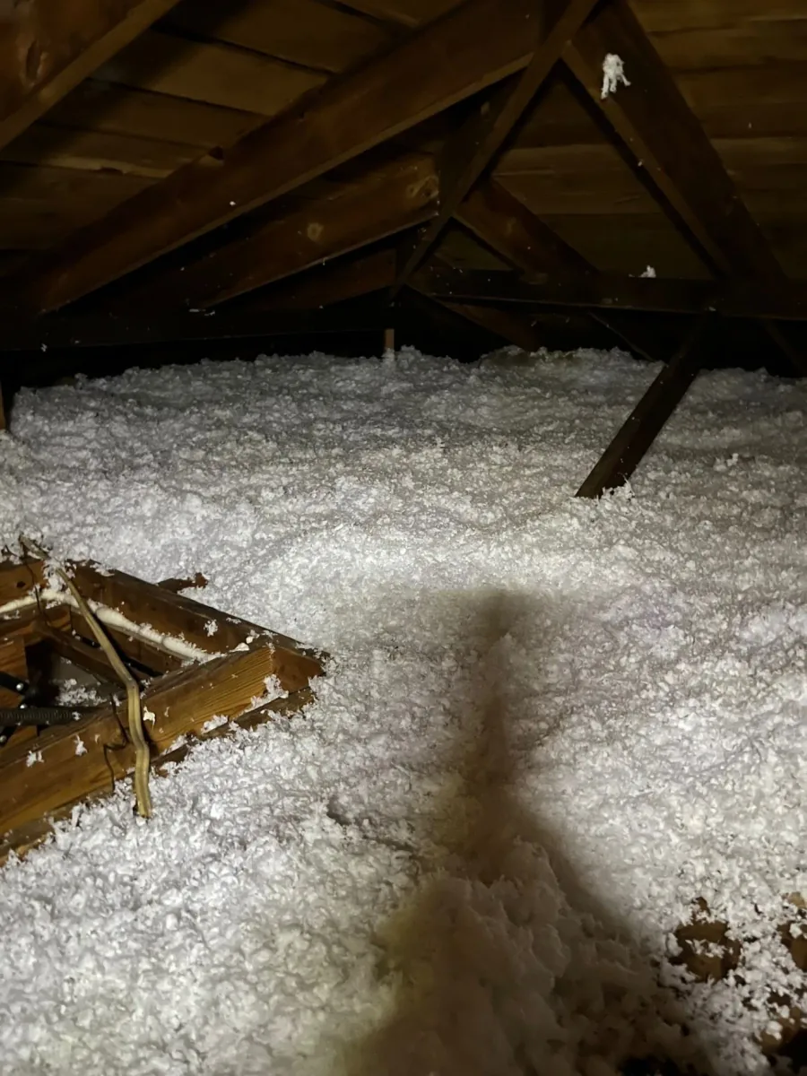 Clean fiberglass insulation coverage around timber supports in an attic